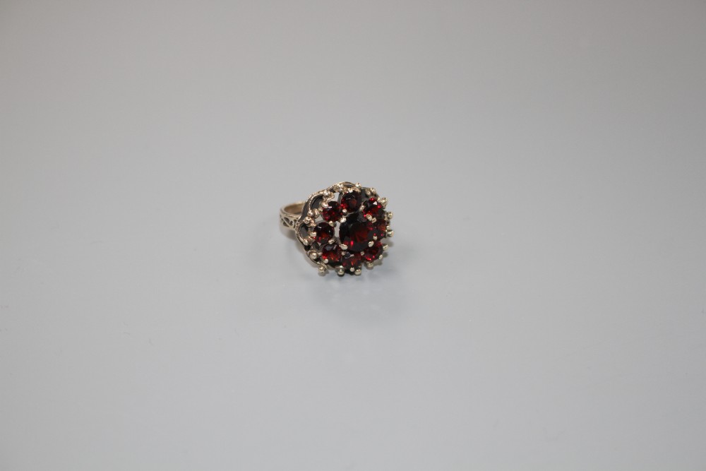 A 14k yellow metal and nine stone garnet cluster dress ring, size O, gross weight 5.6 grams.